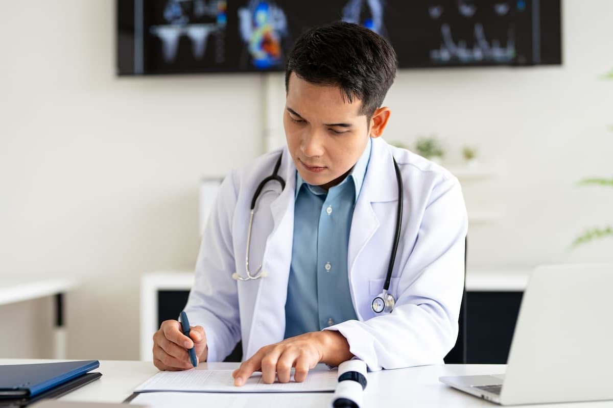 A GP reviewing a referral at their desk