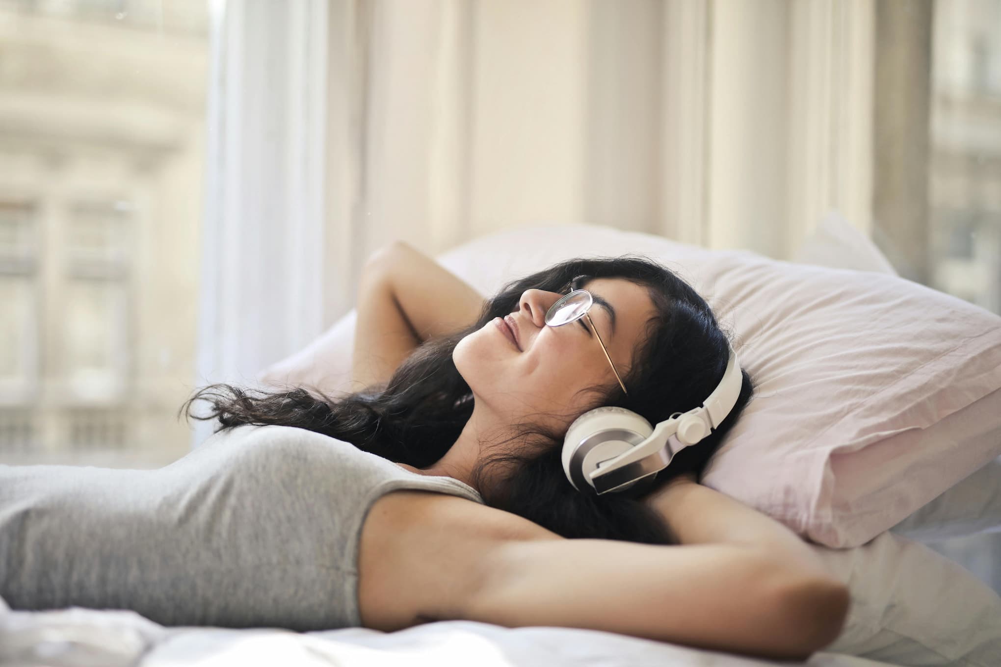 A young person resting with headphones on in a quiet, low-demand space at home