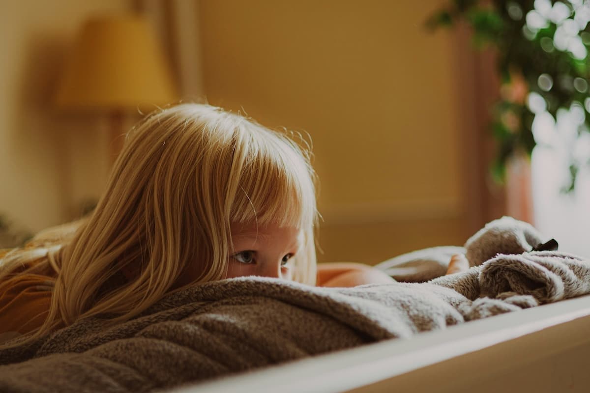 A young person sitting calmly in a school corridor