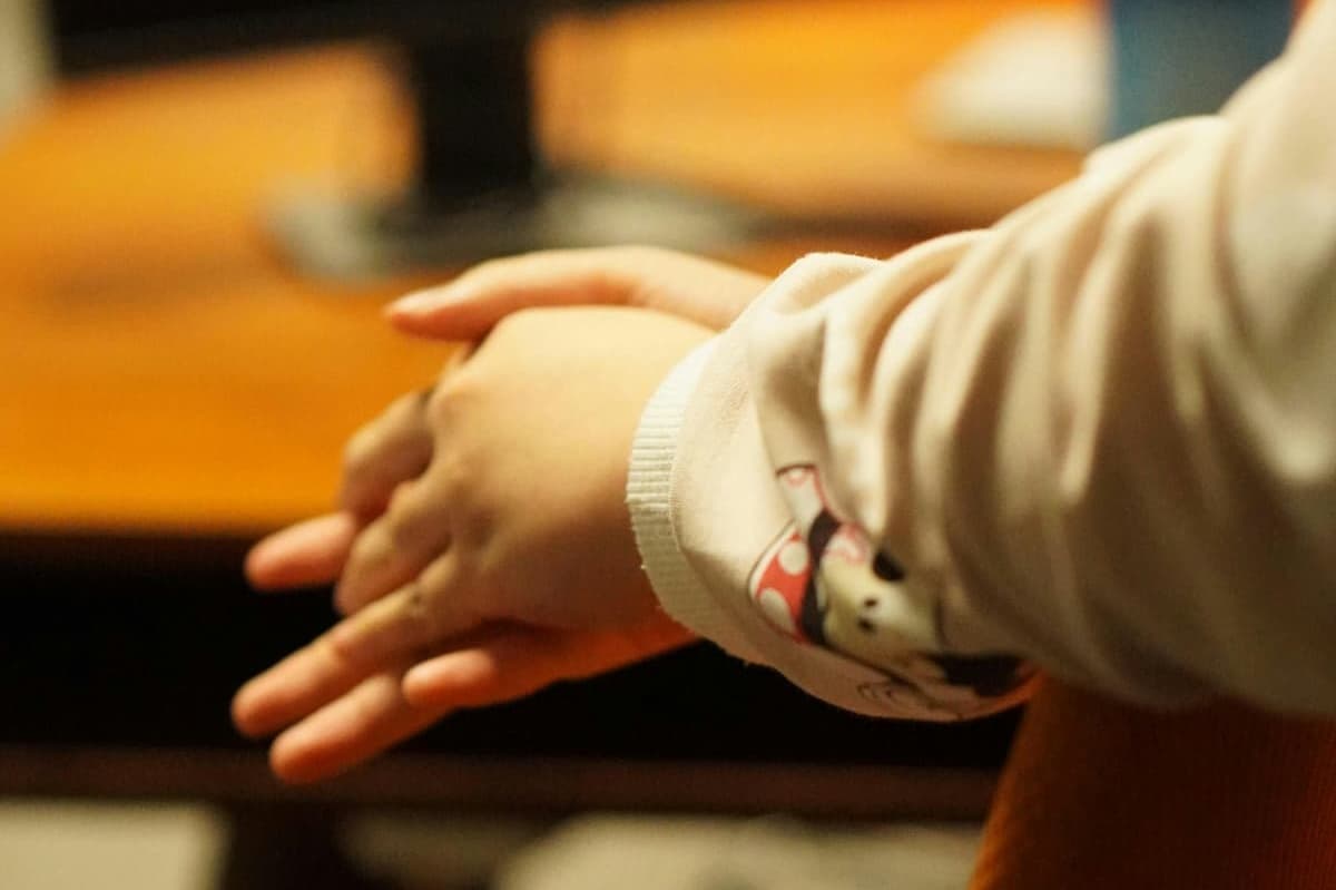 Hands resting on a table in a calm, supportive setting