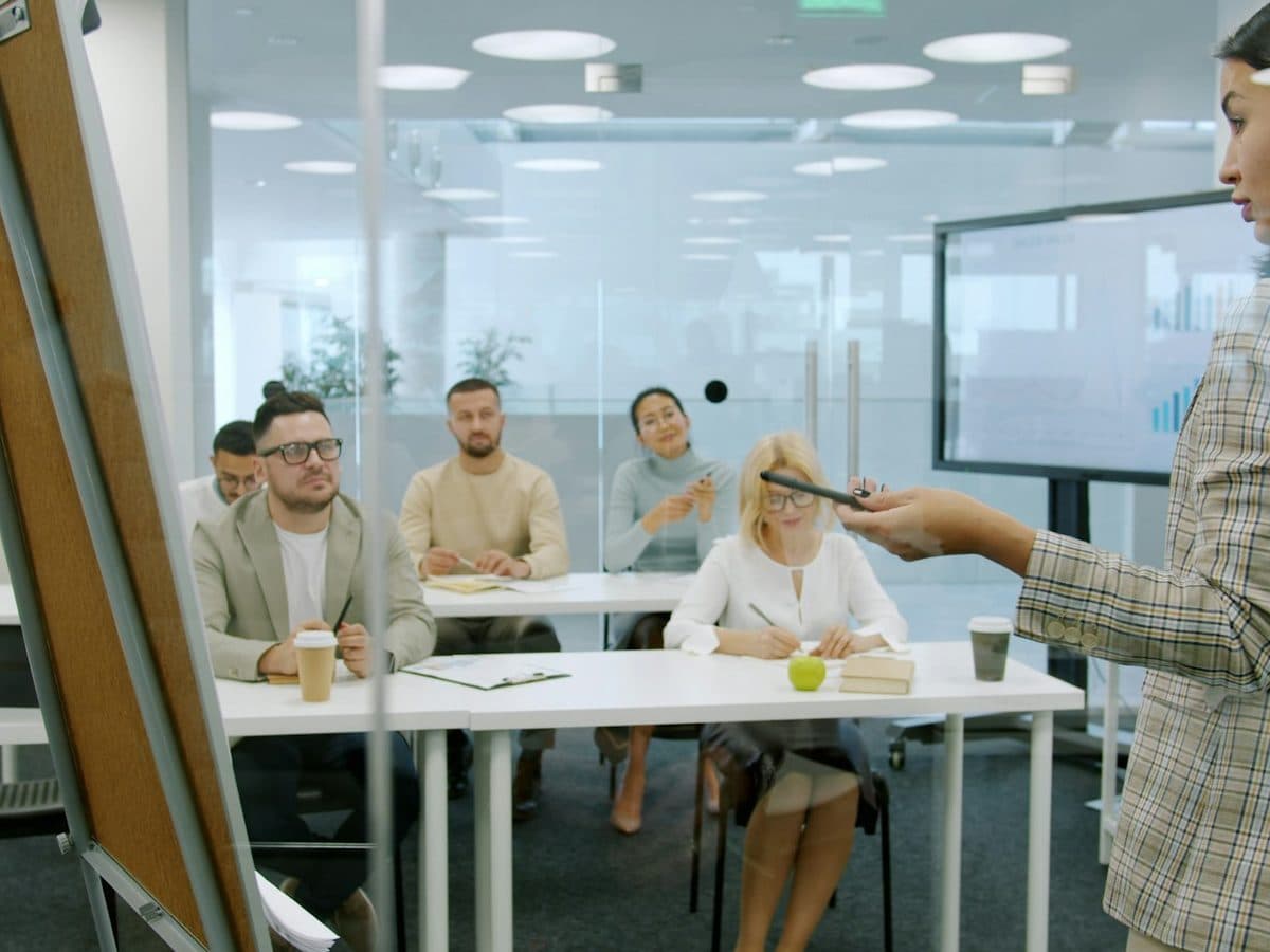 A trainer presenting to a small group seated at tables