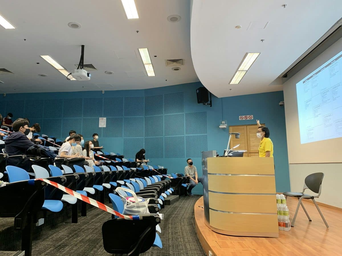 Staff seated in a tiered lecture room facing a screen