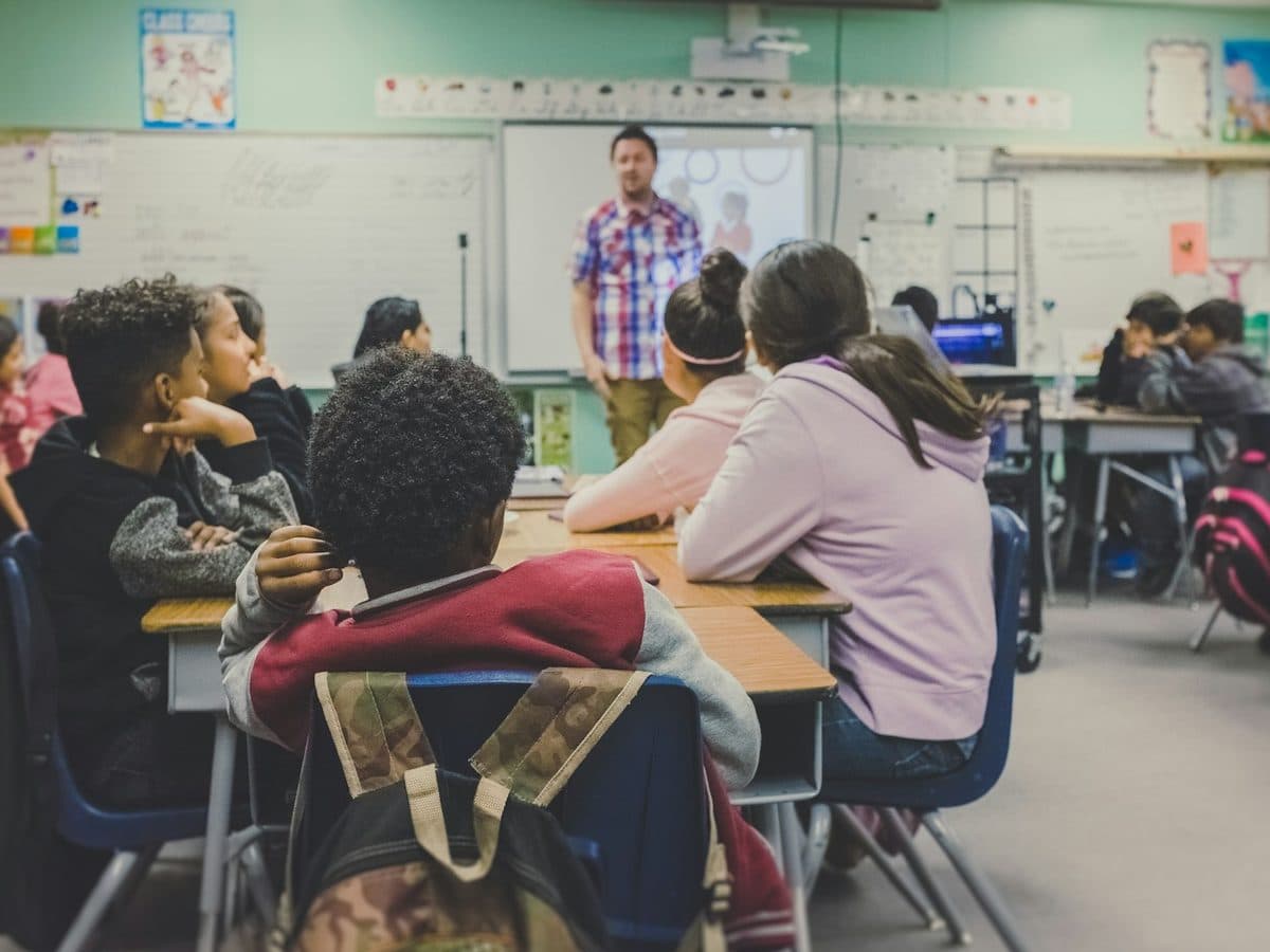 A teacher at the front of a busy classroom